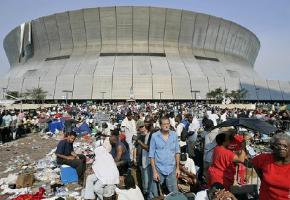 New Orleanians sit outside the Superdome waiting to get a space inside