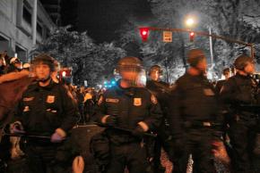 Riot police fill the street between the two parks held by Occupy Portland