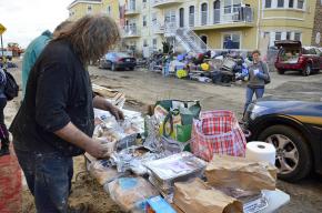 Residents in the Rockaways collect donated food items in a wreckage-strewn street