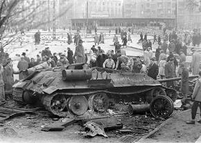 Hungarian workers gather around a gutted Soviet tank in Budapest