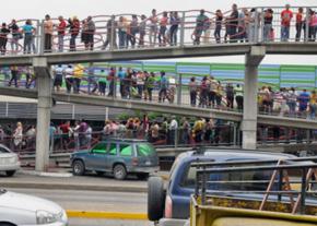Customers line up for hours outside a supermarket in Caracas